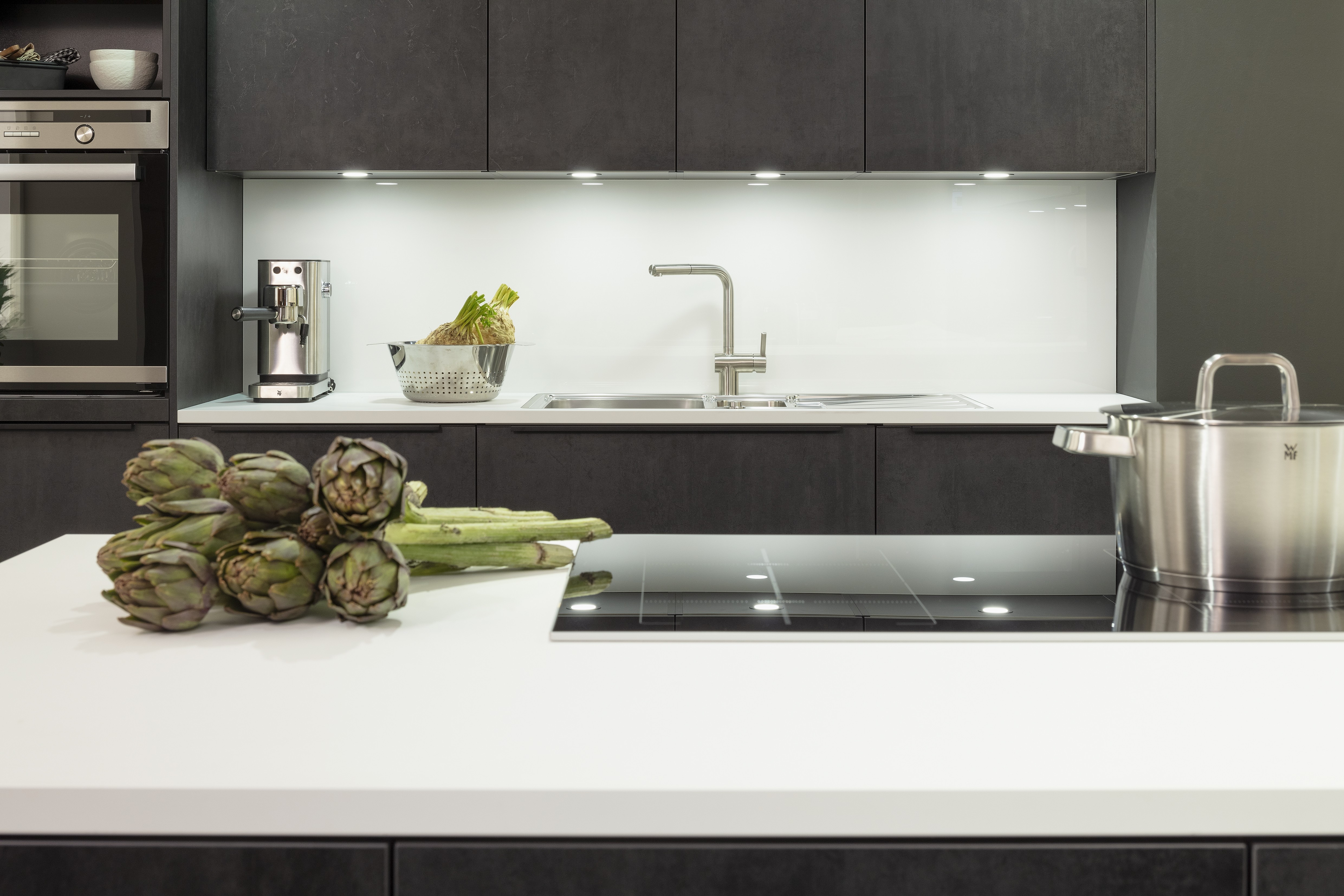 Concept130 Front: Comet Spachtelbeton schwarz Kunststoff strukturiert Murano Bril Kristallweiss Designglas eingefasst APL: Kristallweiß Perfect Sense 25 mm Geräte Blaupunkt Spüle und Armatur: Franke  Features: Dachschräge, Maßeinbau, Sideboard, offene Regale mit Downlights.