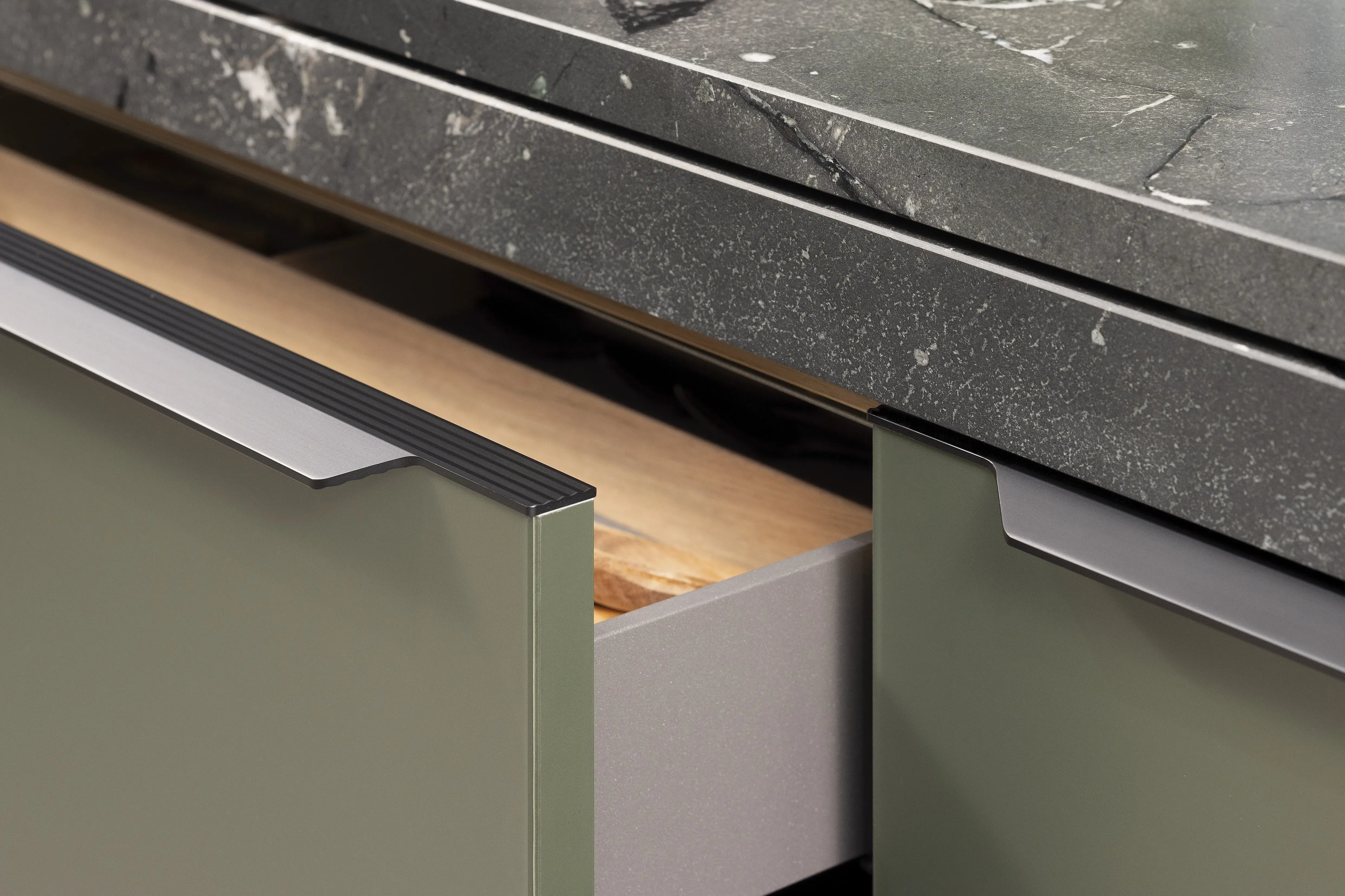 APL: Negresco satiniert (Granit) 25 mm + 50 mm Front: AV 5015 Olivgrün metallic Polymerglas ((PUResist, PURemission) Korpus: 2085 Designkorpus Feineiche-natur Griff: M755 Schwarz Geräte: Bosch Armatur: Blaupunkt Spüle: Blaupunkt  Features: Rolloschrank, Polymerglasoberfläche, APL verschiebbar über Kochfeld, 120 cm Planung, wandhängend (schwebend)