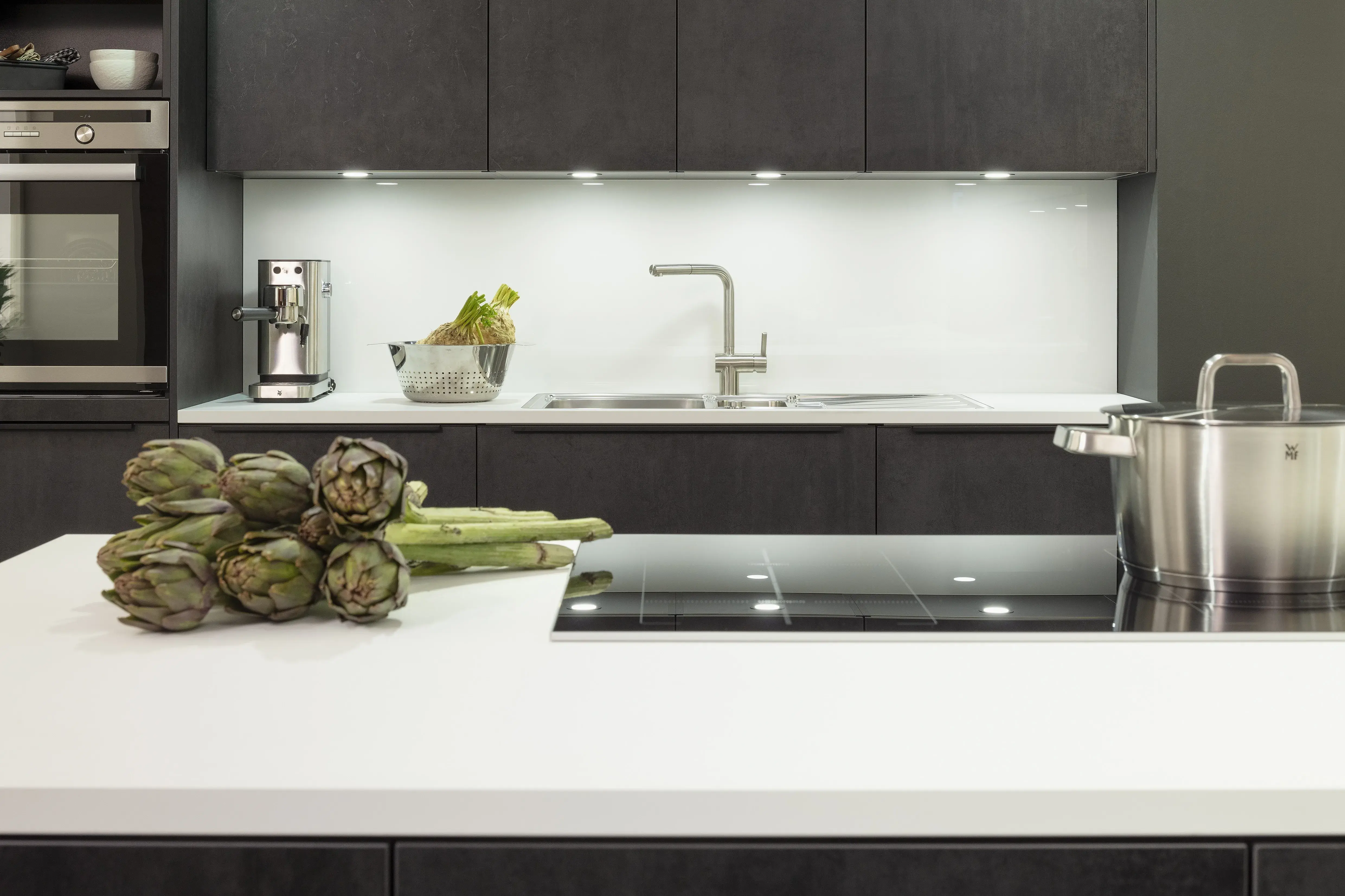 Concept130 Front: Comet Spachtelbeton schwarz Kunststoff strukturiert Murano Bril Kristallweiss Designglas eingefasst APL: Kristallweiß Perfect Sense 25 mm Geräte Blaupunkt Spüle und Armatur: Franke  Features: Dachschräge, Maßeinbau, Sideboard, offene Regale mit Downlights.