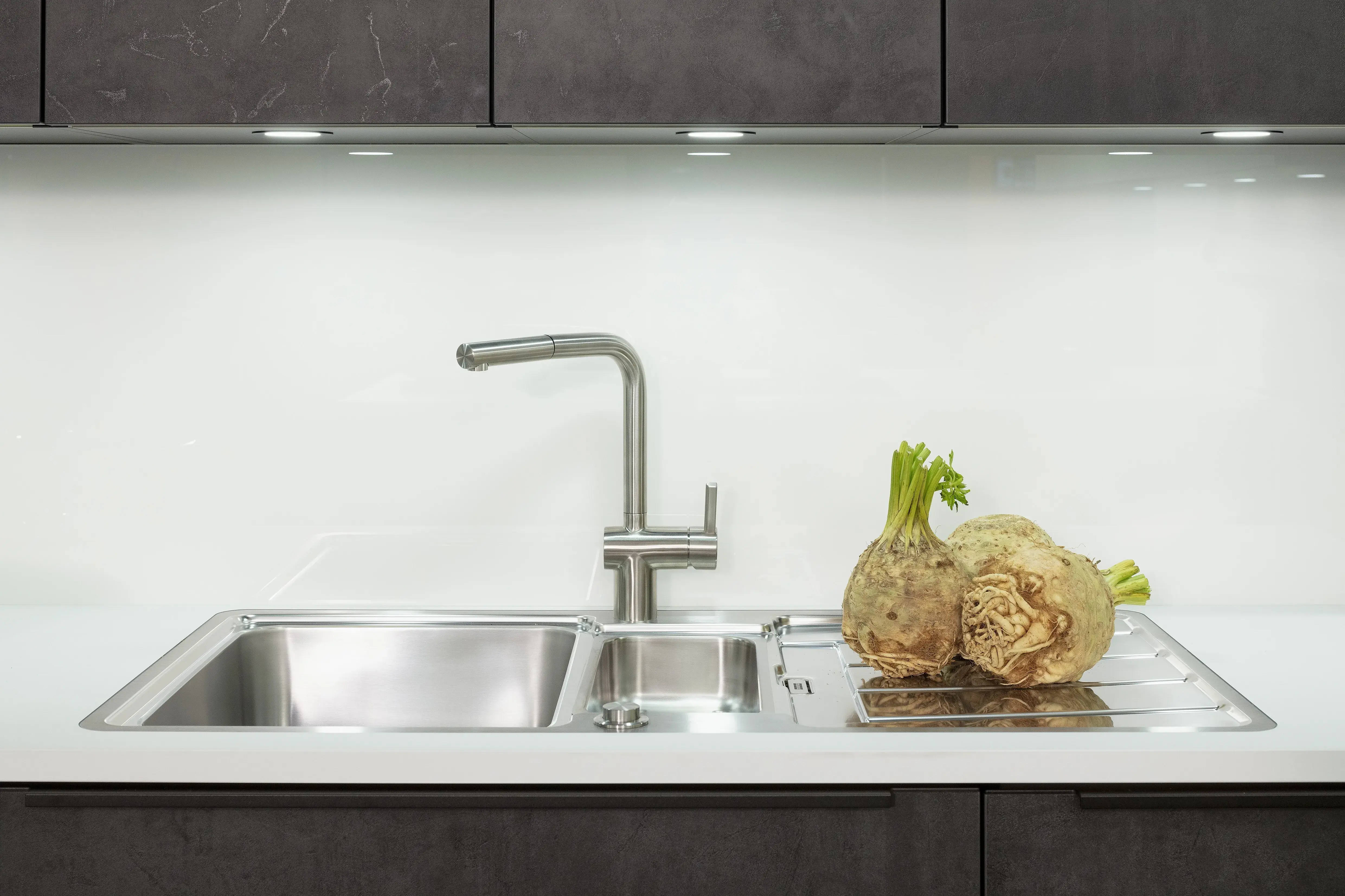 Concept130 Front: Comet Spachtelbeton schwarz Kunststoff strukturiert Murano Bril Kristallweiss Designglas eingefasst APL: Kristallweiß Perfect Sense 25 mm Geräte Blaupunkt Spüle und Armatur: Franke  Features: Dachschräge, Maßeinbau, Sideboard, offene Regale mit Downlights.